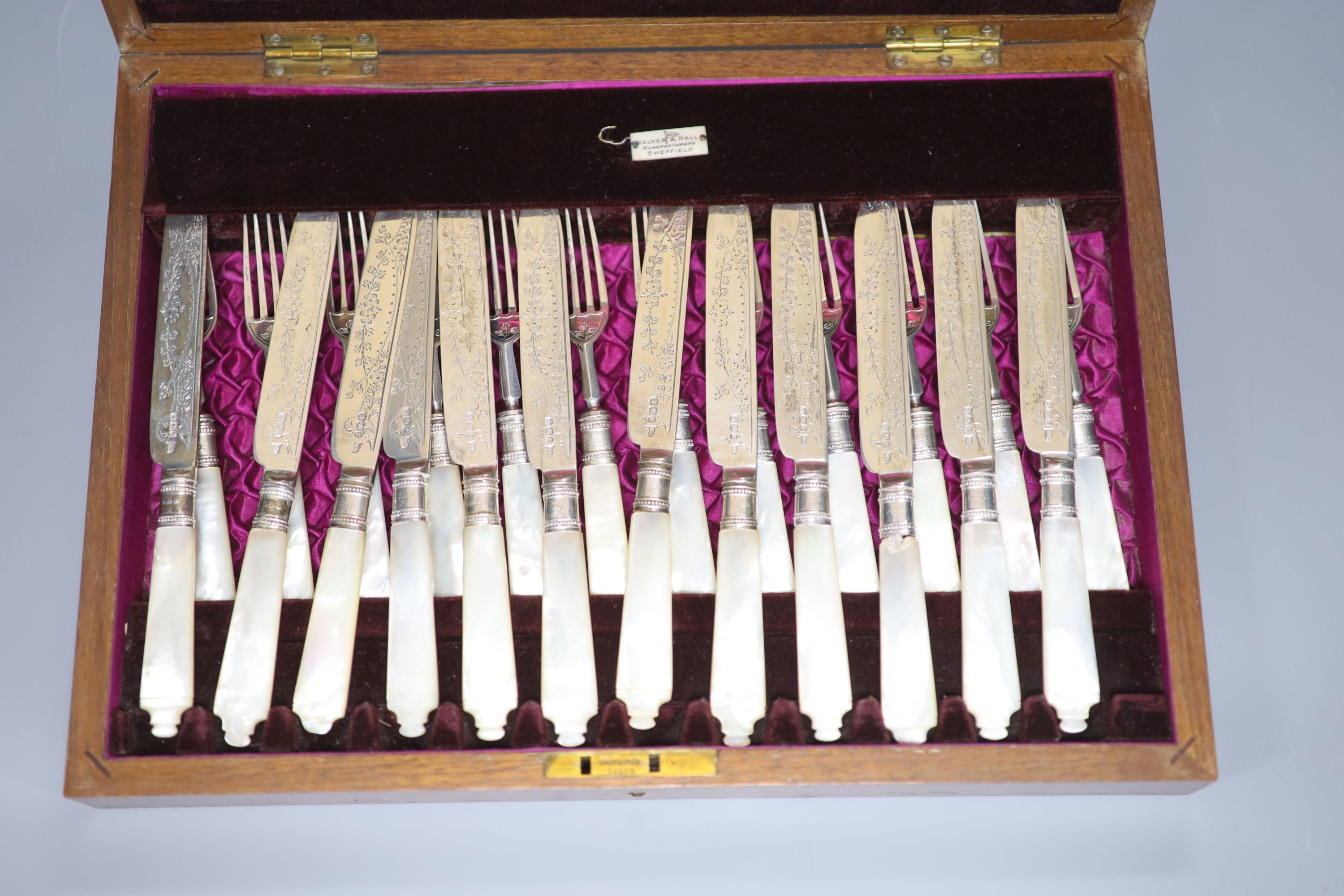 A cased set of twelve pairs of mother of pearl handled silver dessert eaters, Walker & Hall, Sheffield, 1897/1904
